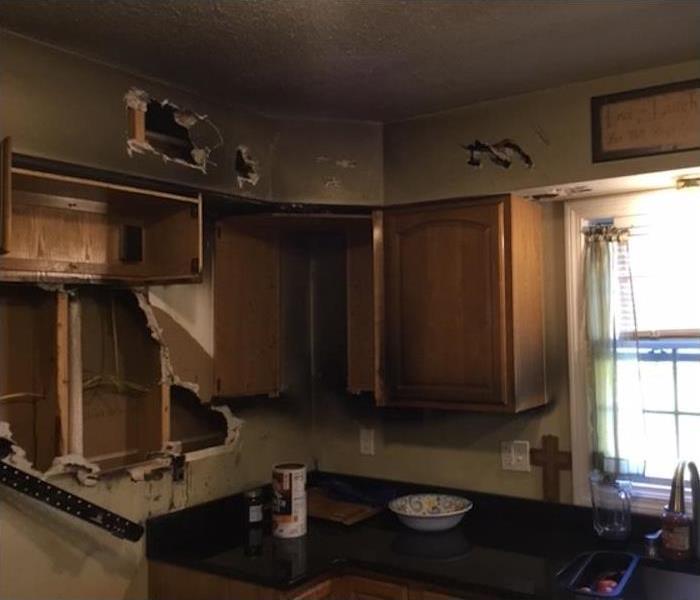 kitchen with fire damage and torn out cabinets