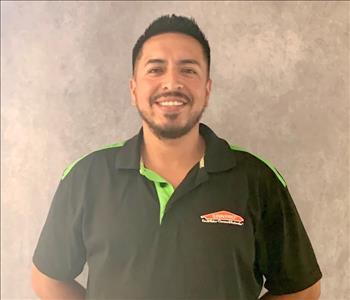 employee in a black logo SERVPRO jacket, posing