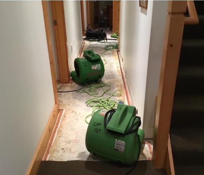 SERVPRO drying equipment in a water damaged hallway