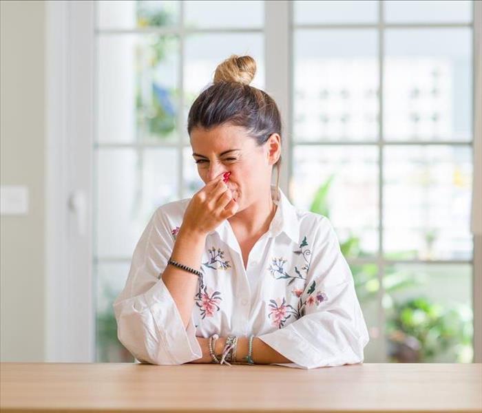 Woman holding her nose