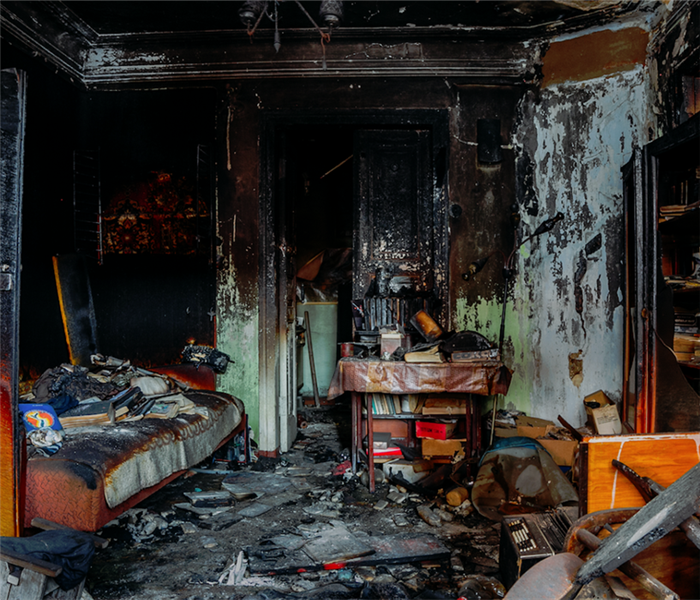 a fire damaged room with soot covering everything