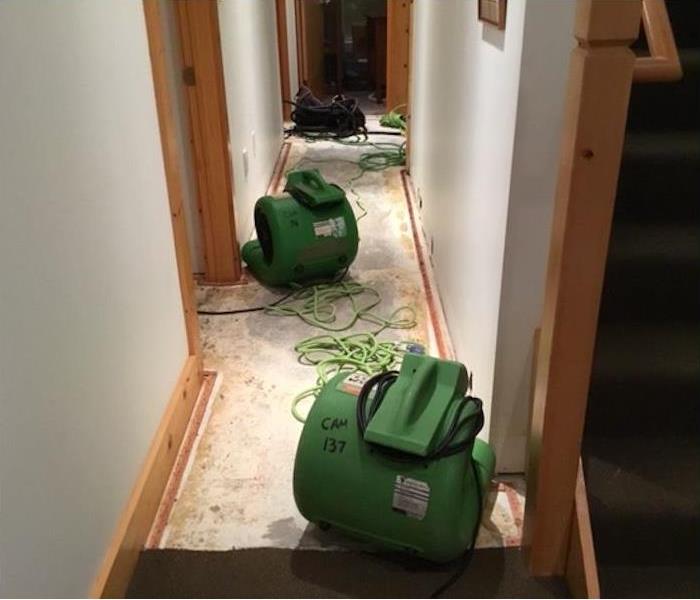 SERVPRO drying equipment in a water damaged hallway