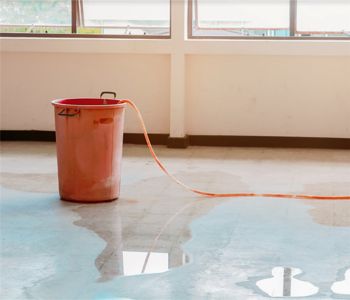 water leaking in a building into a orange bucket